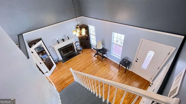 living room featuring a chandelier, a fireplace with flush hearth, lofted ceiling, and wood finished floors