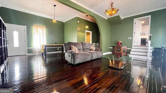 living area featuring hardwood / wood-style flooring, baseboards, arched walkways, and ornamental molding