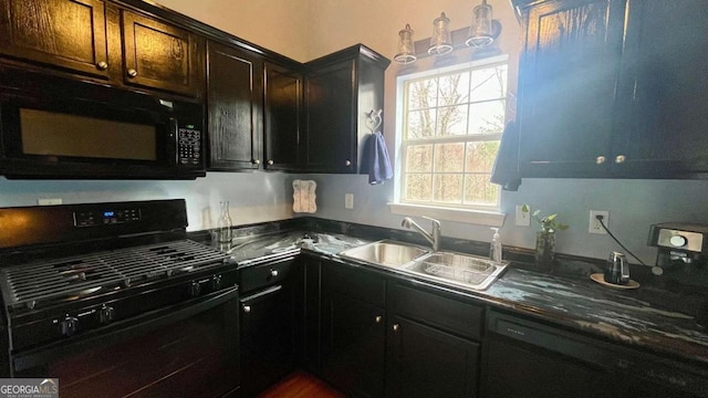 kitchen with dark countertops, black appliances, and a sink