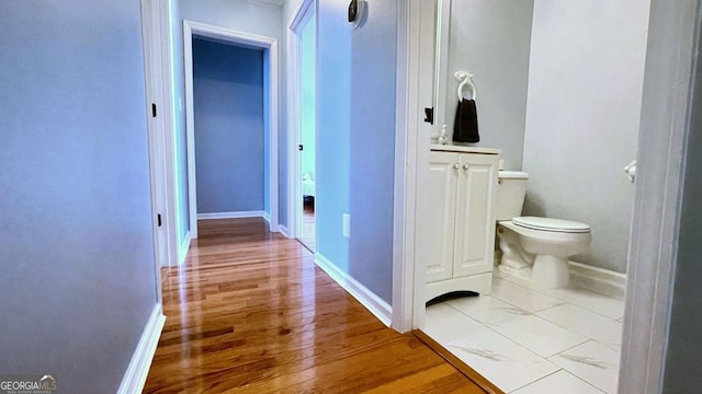 hall featuring baseboards and wood finished floors