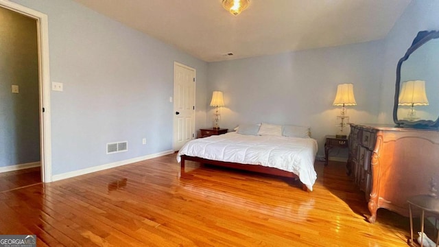 bedroom featuring visible vents, baseboards, and light wood-style floors