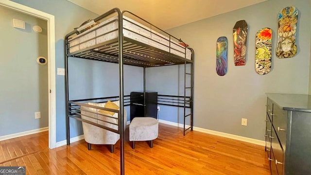 bedroom featuring baseboards and wood finished floors