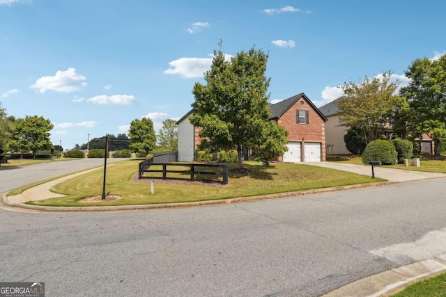 view of front of property with fence, concrete driveway, a front yard, a garage, and brick siding