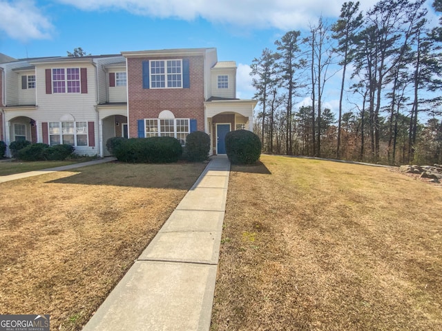 view of front facade featuring brick siding and a front yard