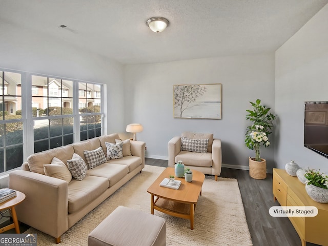 living room with visible vents, baseboards, and wood finished floors