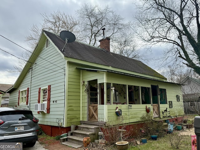 exterior space featuring cooling unit, a chimney, and entry steps