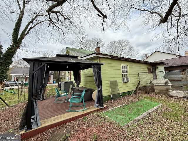 back of house featuring a gazebo, cooling unit, a wooden deck, and a chimney