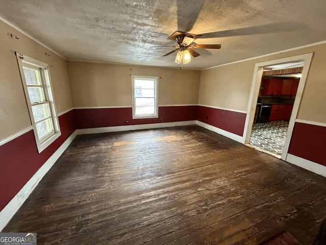 empty room featuring a ceiling fan, ornamental molding, wood finished floors, and a textured ceiling