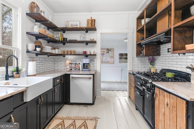 kitchen featuring open shelves, under cabinet range hood, double oven range, dishwashing machine, and a sink