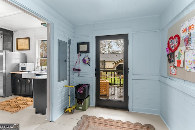 doorway featuring electric panel and a sink