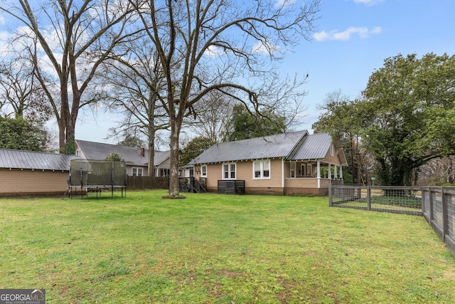 view of yard featuring a trampoline and a fenced backyard