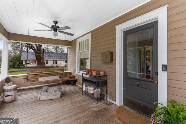 wooden terrace with covered porch and ceiling fan