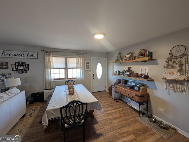 dining space with baseboards and wood finished floors