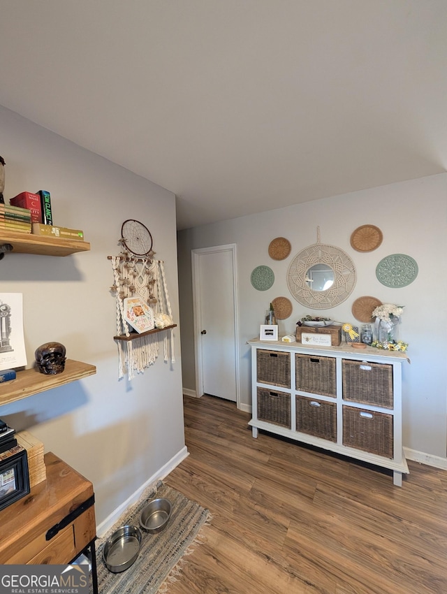 hall with baseboards and wood finished floors