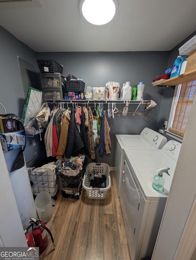 clothes washing area featuring washer and dryer, laundry area, and wood finished floors