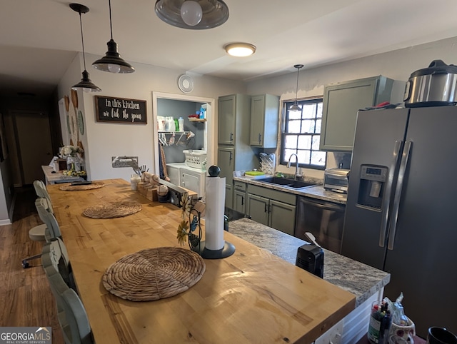 kitchen with a sink, dark wood-style floors, stainless steel fridge with ice dispenser, wooden counters, and dishwasher