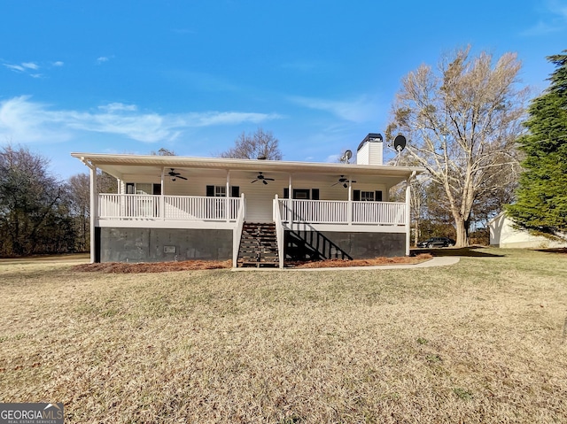 back of property featuring stairway, a lawn, a chimney, and a ceiling fan