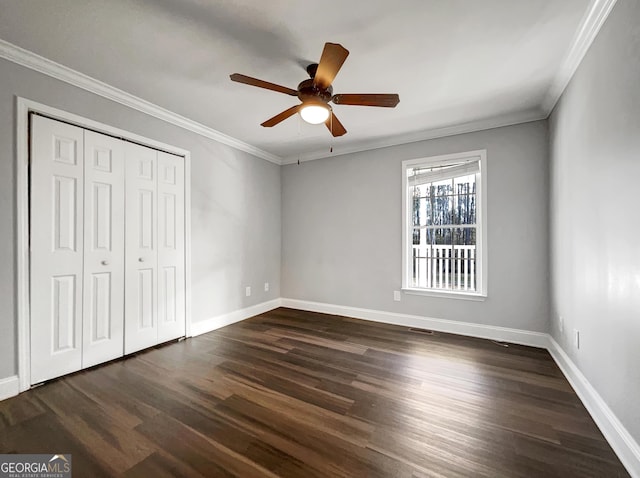 unfurnished bedroom with dark wood-style floors, baseboards, a closet, and ornamental molding