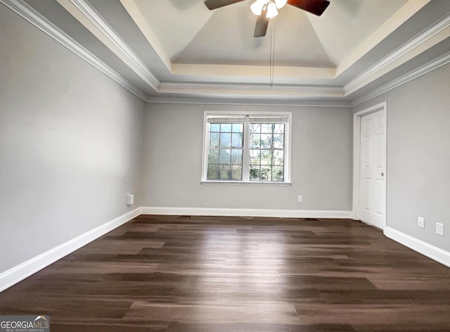 unfurnished room with dark wood finished floors, a raised ceiling, and baseboards