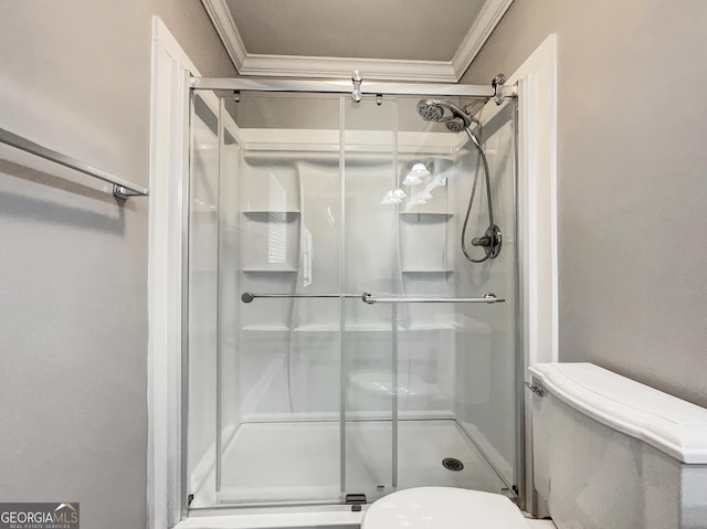 bathroom with crown molding, toilet, and a stall shower