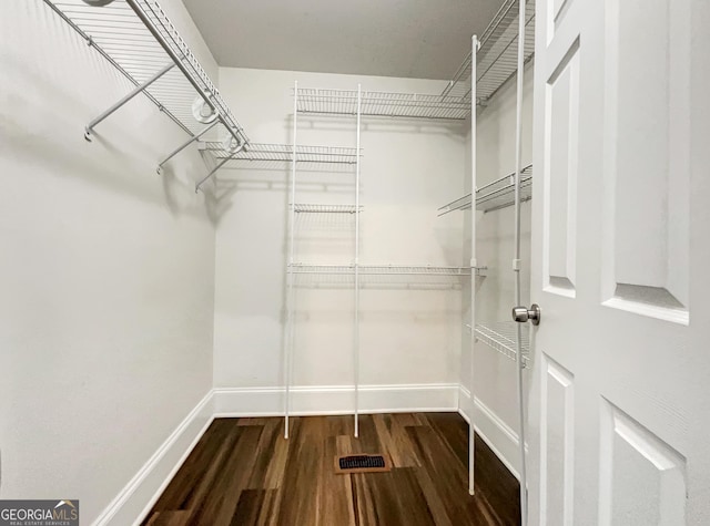 walk in closet with wood finished floors