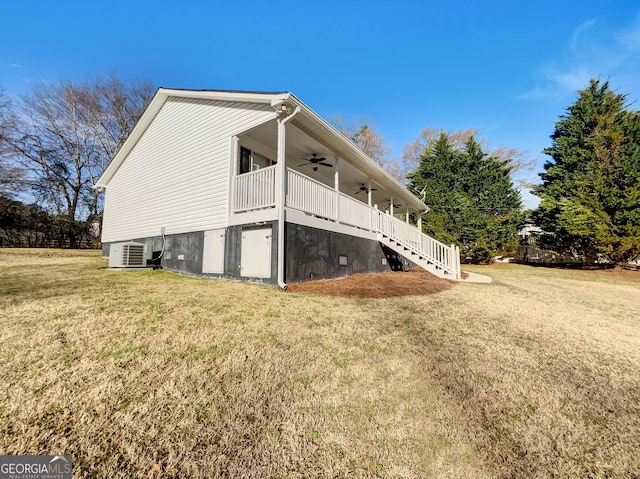 view of side of property with a yard, central AC unit, stairs, and a ceiling fan