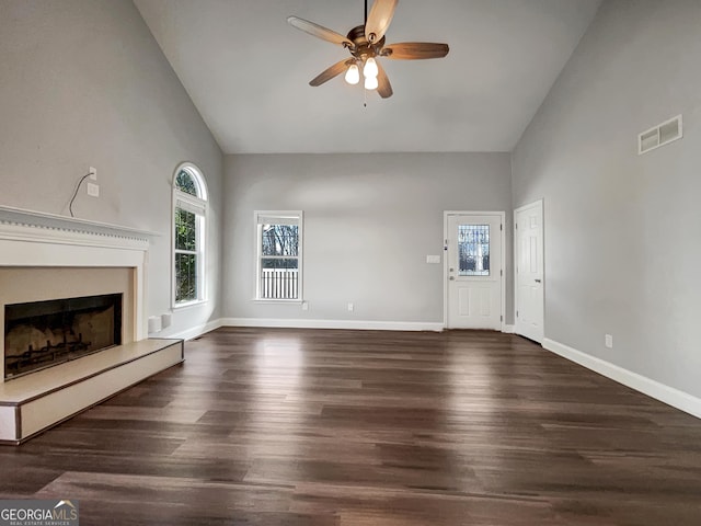 unfurnished living room featuring wood finished floors, visible vents, and a fireplace with raised hearth