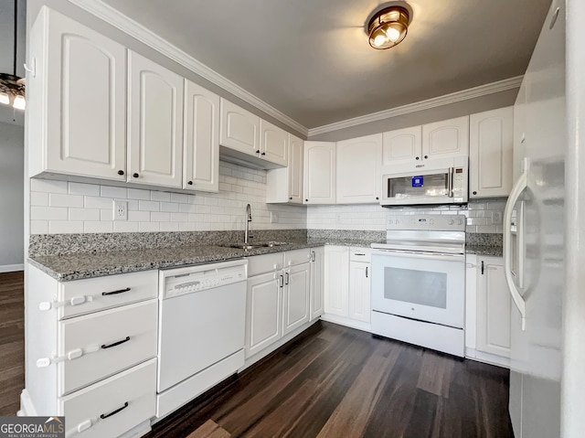 kitchen featuring dark wood finished floors, white appliances, stone countertops, and a sink