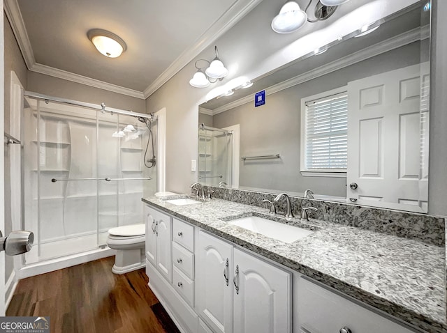 bathroom with a shower stall, crown molding, and a sink