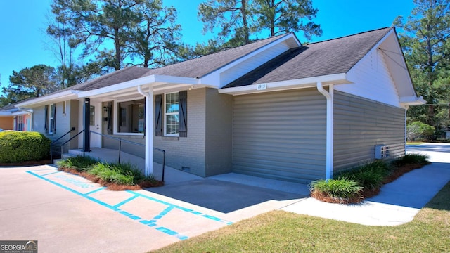 view of property exterior with crawl space, brick siding, and a shingled roof