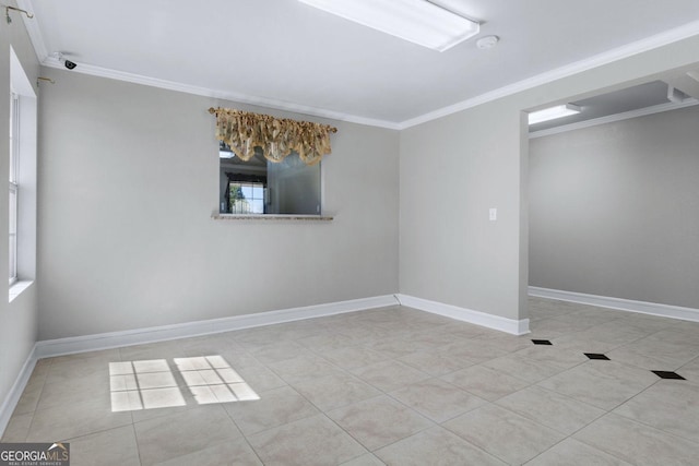 spare room with tile patterned floors, baseboards, and ornamental molding