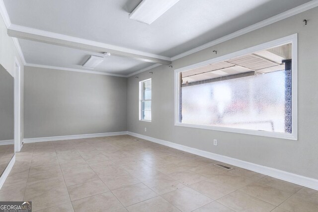 spare room featuring visible vents, baseboards, crown molding, and tile patterned flooring