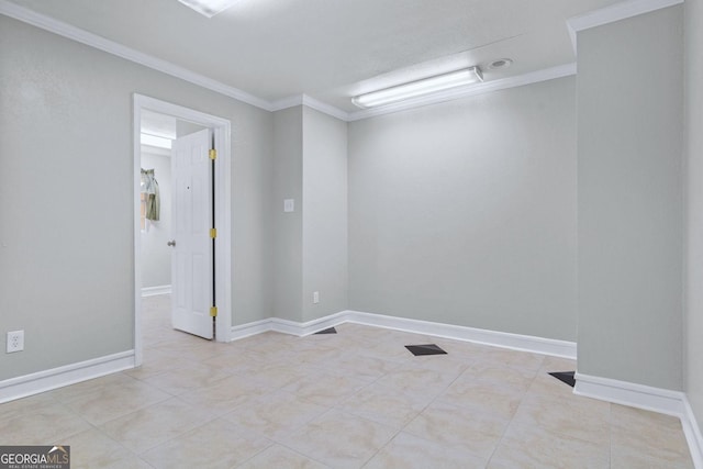 spare room with tile patterned flooring, crown molding, and baseboards