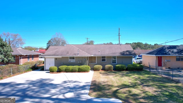 ranch-style home featuring a front yard, fence, and driveway