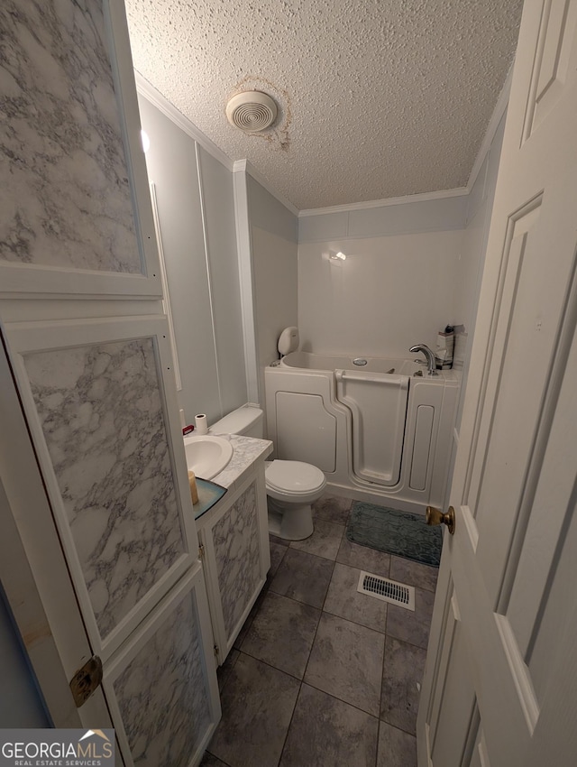 full bath featuring a bath, visible vents, a textured ceiling, and ornamental molding