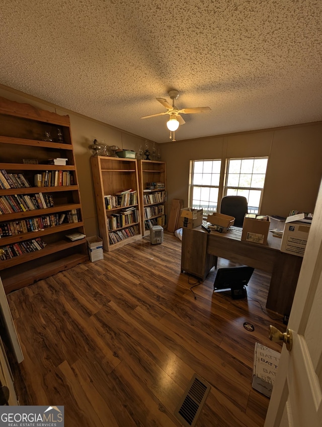 home office featuring visible vents, a textured ceiling, ceiling fan, and wood finished floors