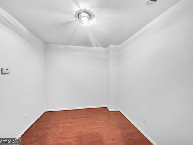 spare room with visible vents, wood finished floors, and baseboards