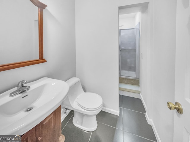 bathroom featuring tile patterned flooring, toilet, baseboards, and a sink