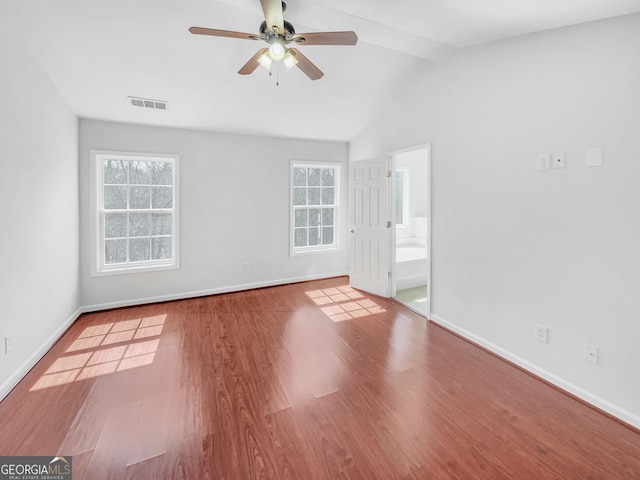 empty room featuring visible vents, a healthy amount of sunlight, ceiling fan, and wood finished floors