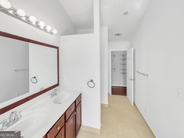 full bathroom with tile patterned flooring, visible vents, double vanity, and a sink