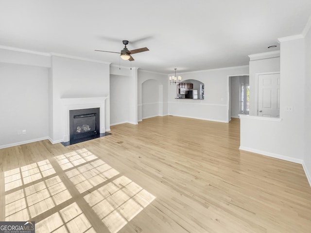 unfurnished living room featuring crown molding, baseboards, a fireplace with flush hearth, light wood-type flooring, and ceiling fan with notable chandelier