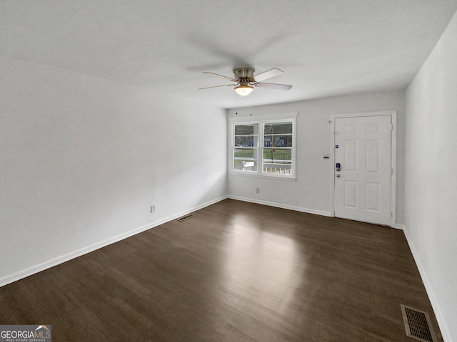 interior space with dark wood-type flooring, baseboards, visible vents, and ceiling fan