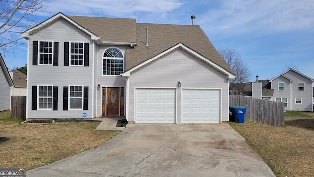 traditional home with driveway, an attached garage, and fence