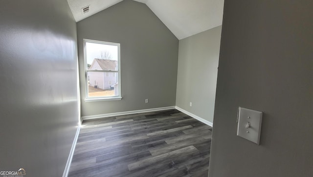 interior space with dark wood-style floors, visible vents, baseboards, and vaulted ceiling