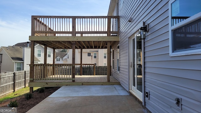 view of patio featuring a wooden deck and fence