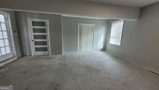 unfurnished bedroom featuring a closet and concrete floors