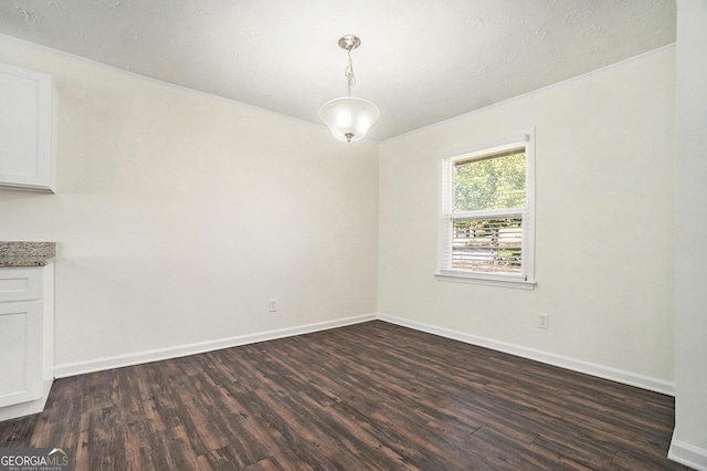 unfurnished dining area with baseboards and dark wood-style flooring