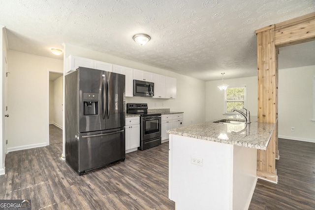 kitchen with a sink, appliances with stainless steel finishes, white cabinets, light stone countertops, and dark wood-style flooring