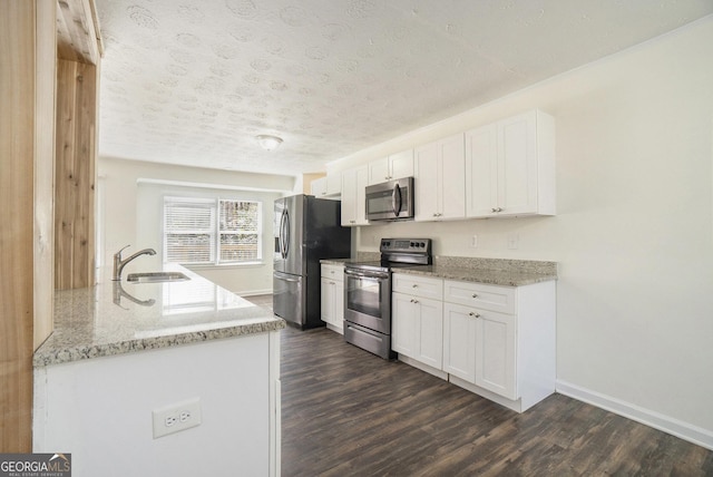 kitchen featuring a sink, appliances with stainless steel finishes, dark wood-style flooring, and white cabinetry