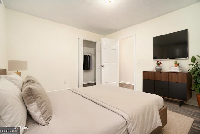 bedroom featuring a closet, baseboards, and wood finished floors